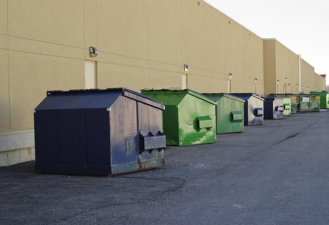 tilted front-load dumpsters being emptied by waste management workers in Buckner